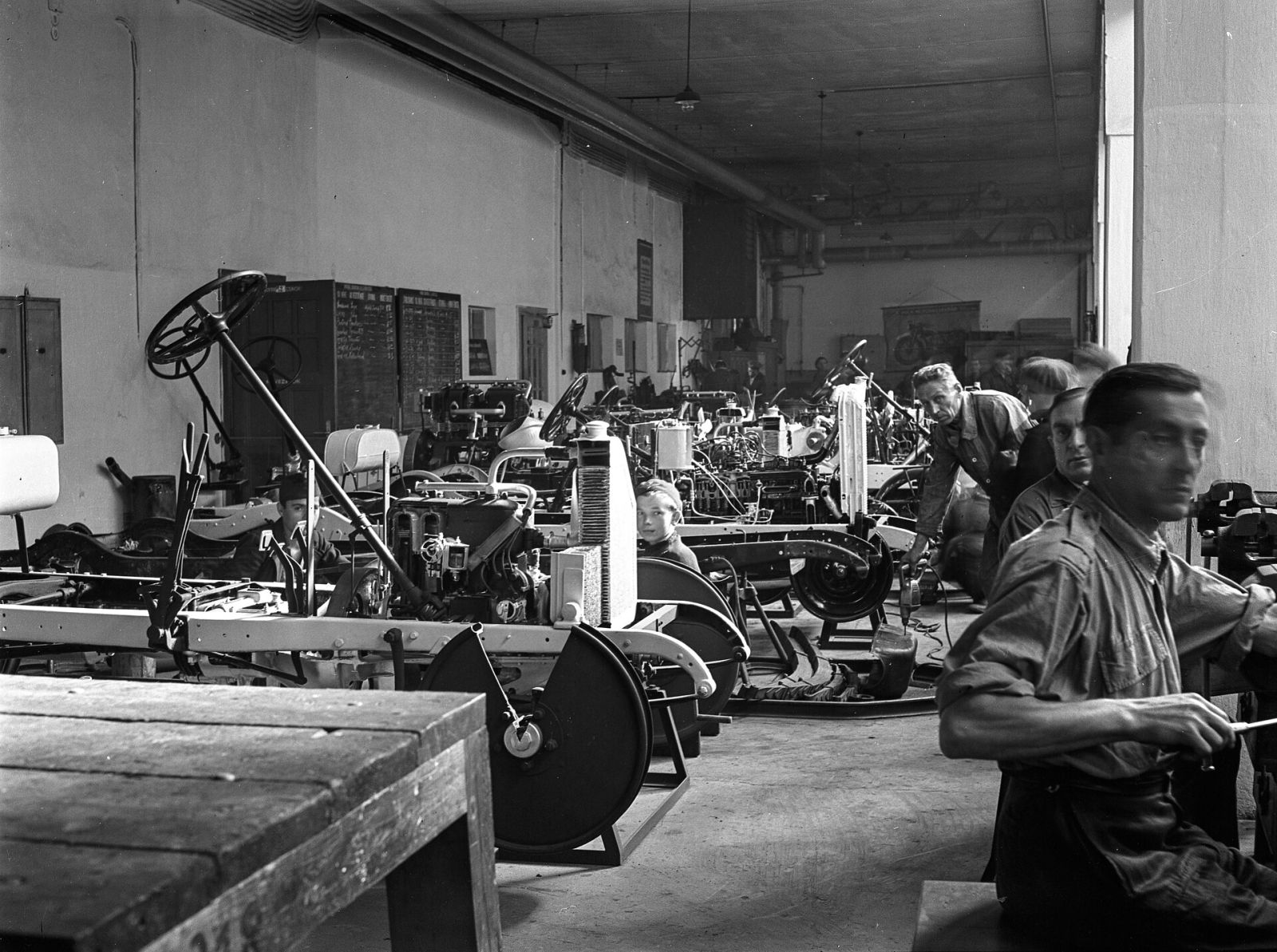Mecánico trabajando en el motor de un coche clásico en un taller antiguo